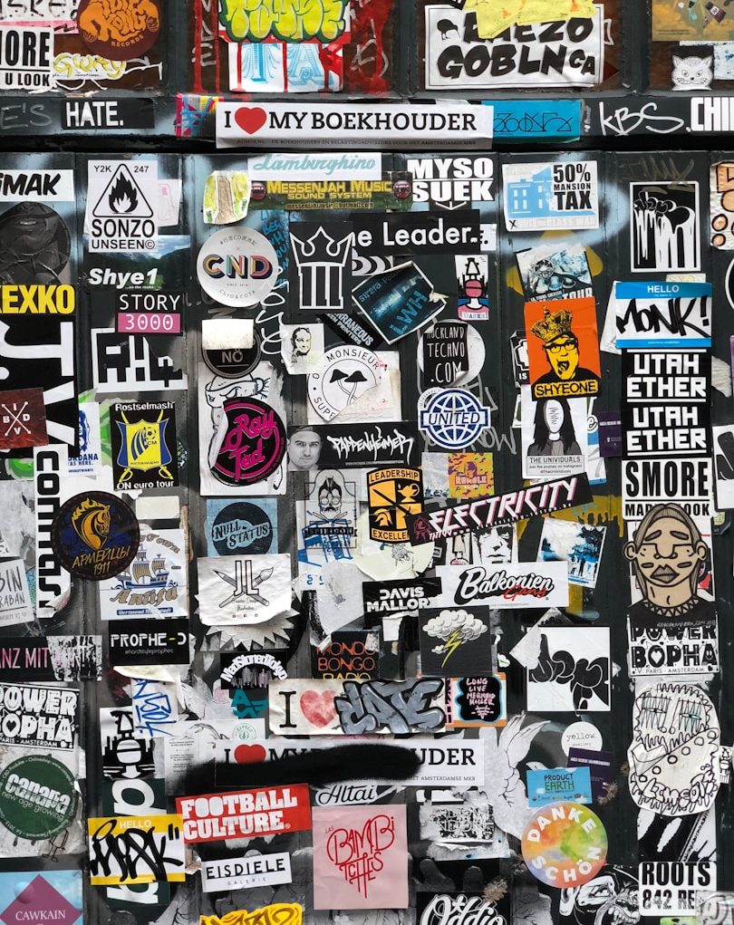 A collage of various colourful stickers and logos on a dark background.